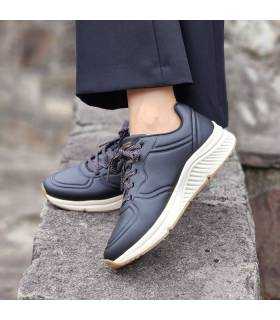 pies cruzados con las zapatillas negras de invierno de Skechers para mujer