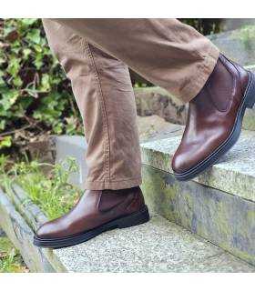 hombre bajando escaleras con los botines Chelsea marrones de piel fabricados por Baerchi puestos