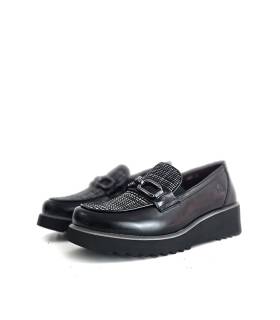 Mocasines de mujer Treintas en piel negra con cuña puestos sobre fondo blanco