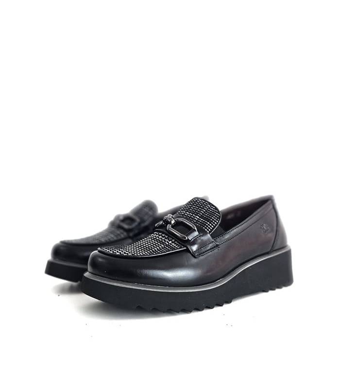 Mocasines de mujer Treintas en piel negra con cuña puestos sobre fondo blanco