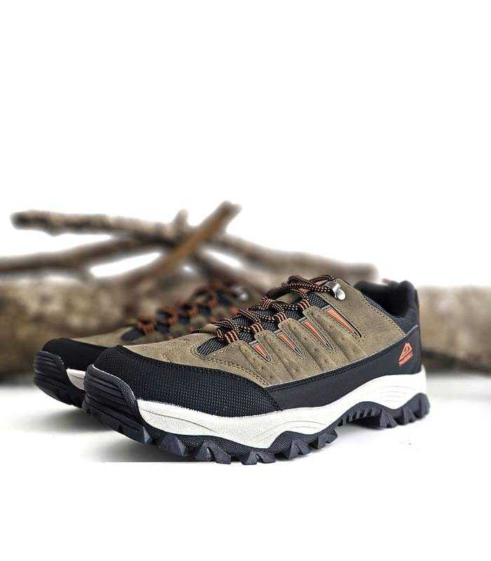 zapatillas trekking hombre Paredes Sollana color kaki puestas sobre fondo de ramas secas