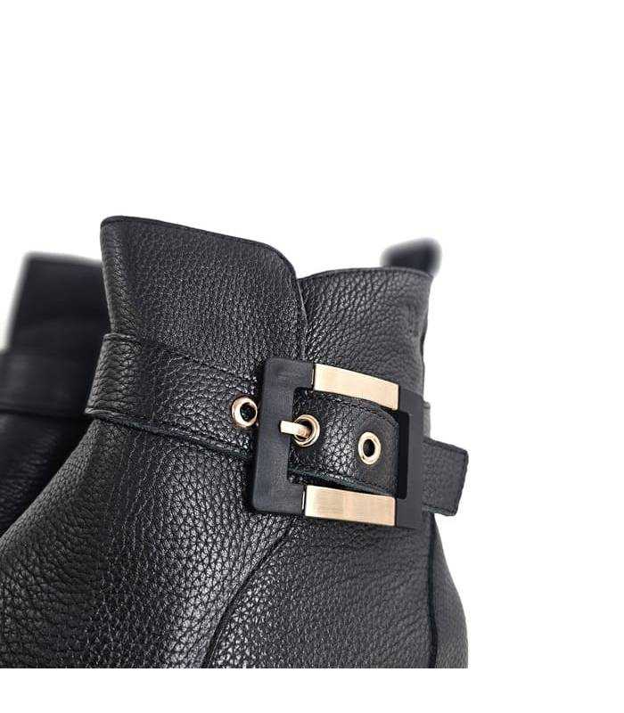 Detalle hebilla dorada botines negros mujer Treintas