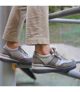 Zapatos deportivos taupe MySoft puestos sobre barandilla metálica, ideales para caminar cómodamente en el día a día.