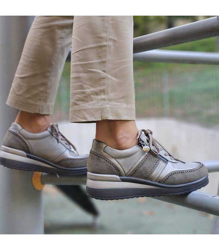 Zapatos deportivos taupe MySoft puestos sobre barandilla metálica, ideales para caminar cómodamente en el día a día.