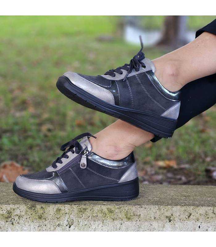 Zapatos deportivos negros MySoft con cordones puestos en exterior sobre bordillo, vista lateral.