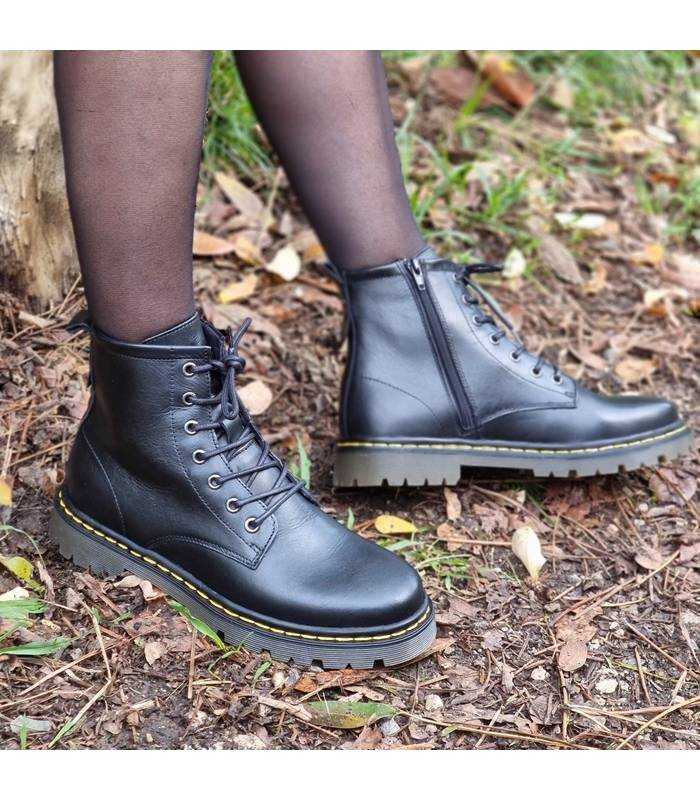 vista lateral exterior botas negras mujer en el campo