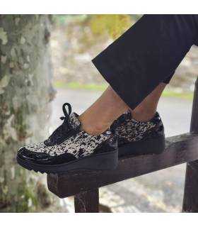 modelo posando con los zapatos negros y animal print de mujer fabricados por Nival puestos