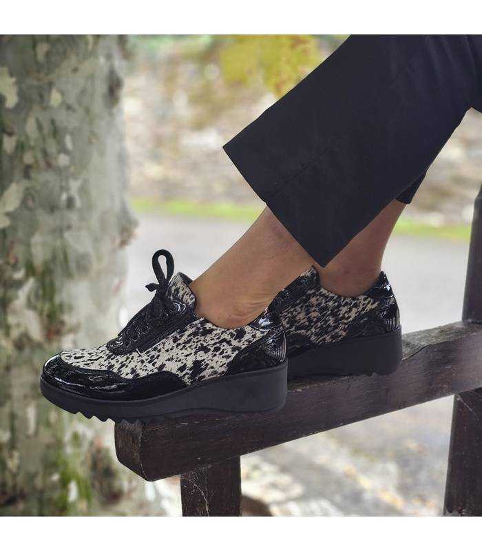 modelo posando con los zapatos negros y animal print de mujer fabricados por Nival puestos
