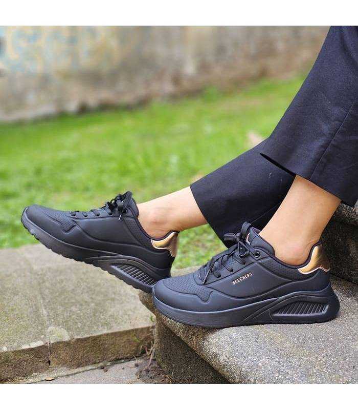 vista lateral de los deportivos negros de mujer modelo Shimmer puestos