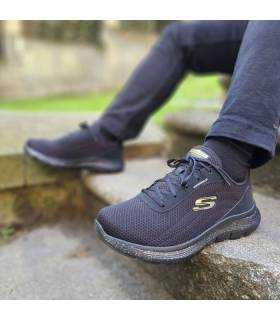 hombre posando con las zapatillas deportivas negras impermeables de Skechers