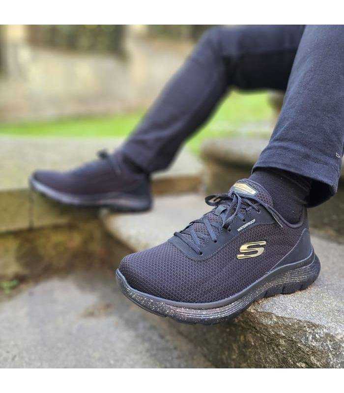 hombre posando con las zapatillas deportivas negras impermeables de Skechers