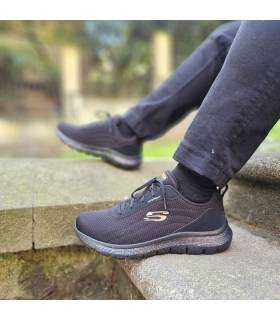 hombre posando con las zapatillas deportivas negras impermeables de Skechers puestas