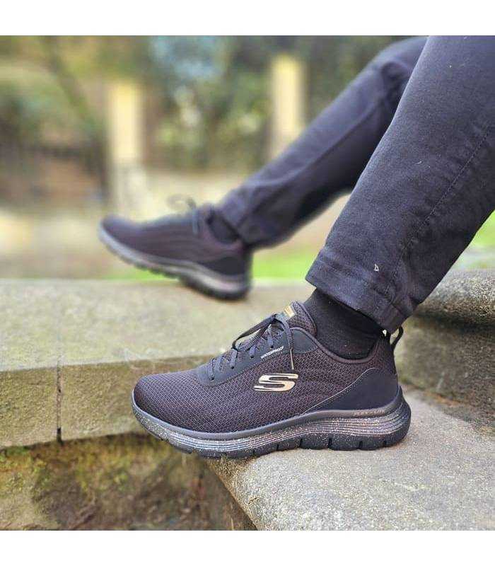 hombre posando con las zapatillas deportivas negras impermeables de Skechers puestas