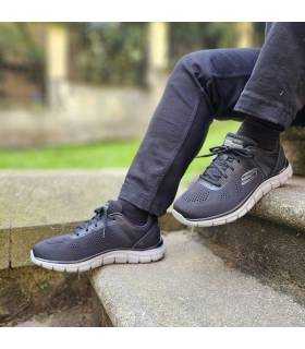 zapatillas-deportivas-hombre-skechers-track-broader-negras puestas en unas escaleras de piedra