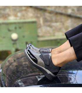 mujer posando sobre un coche con los zapatos negros de mujer con cierre de velcro puestos