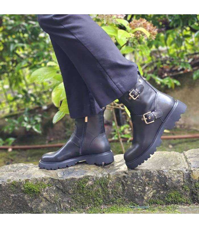 mujer posando con las botas de piel negra con cramllera y hebillas de Carmela puestas