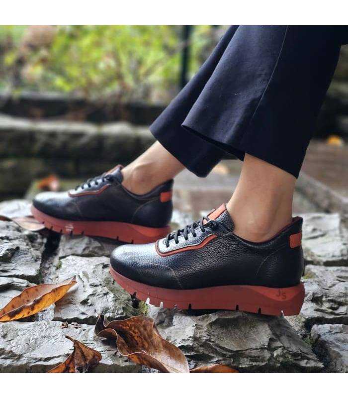 zapatos deportivos negros con detalles en naranja puestos