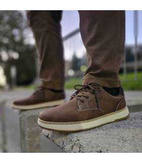 hombre posando con los zapatos impermeables de invierno marones con cordones de Skechers puestos