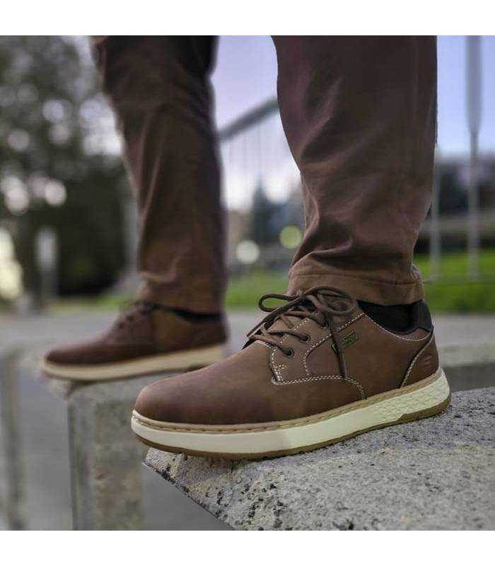 hombre posando con los zapatos impermeables de invierno marones con cordones de Skechers puestos