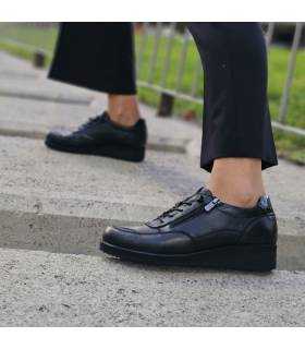 zapatos con cordones elasticos de piel negros para invierno puestos sobre bloques de hormiigón puestos