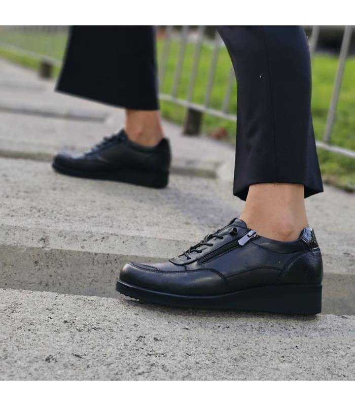 zapatos con cordones elasticos de piel negros para invierno puestos sobre bloques de hormiigón puestos
