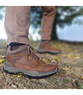 hombre posando con las botas marroones reistentes a la lluvia de Skechers puestas