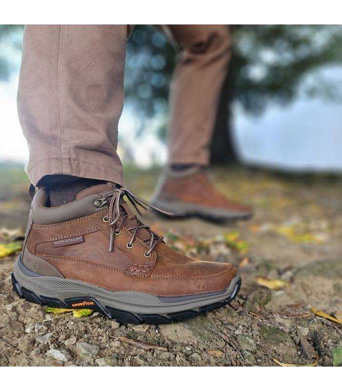 hombre posando con las botas marroones reistentes a la lluvia de Skechers puestas