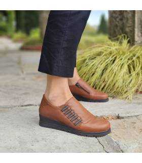 vista de perfil de los zapatos con cuña en piel marrones de mujer puestos