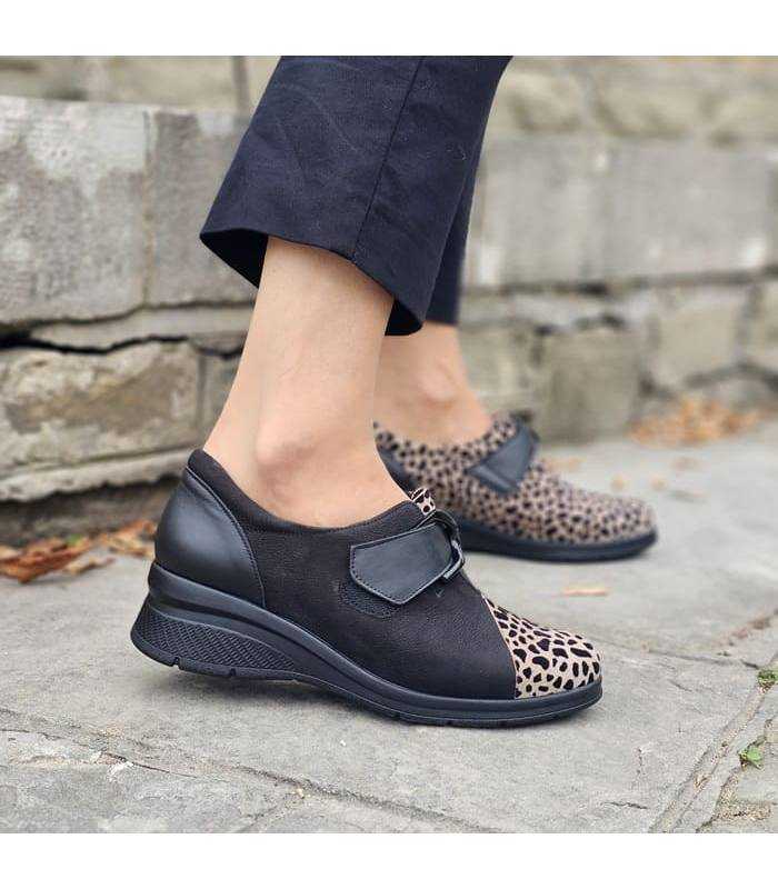 mujer posando con los zapatos comodos negros con animal print puestos