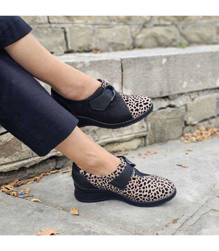 mujer posando con las piernas cruzadas con los zapatos negros y print de Comfort Class puestos