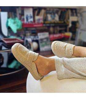 mujer posando en el salon de casa con las zapatillas tipo mocasin descalzas