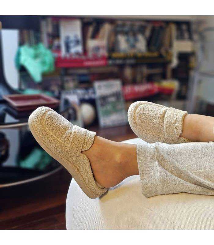 mujer posando en el salon de casa con las zapatillas tipo mocasin descalzas