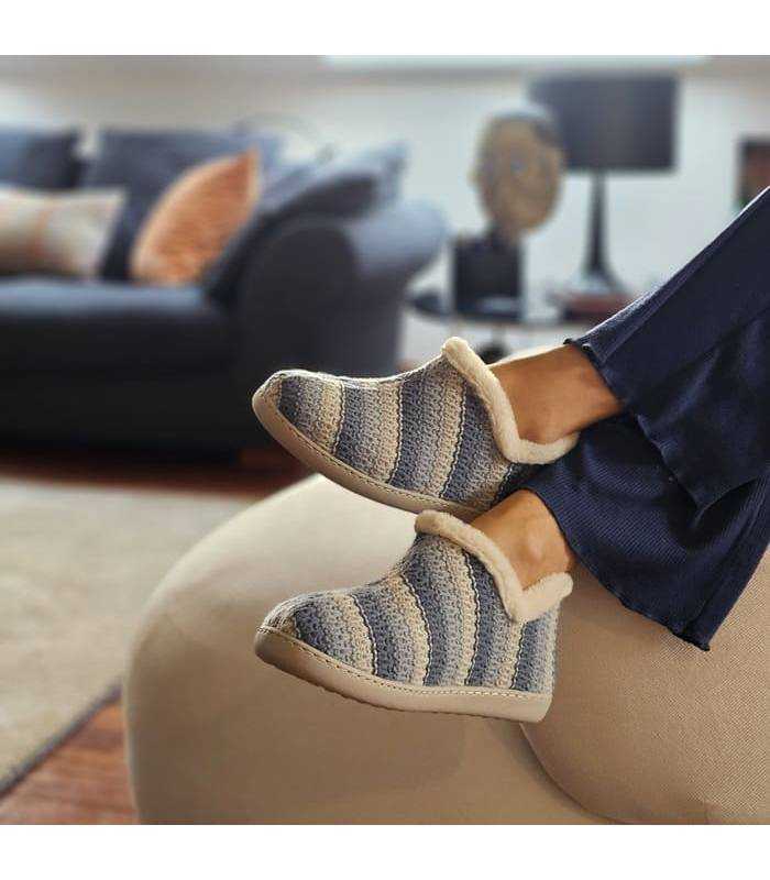 mujer posando en el salon con las zapatillas tipo bota azules de invierno puestas