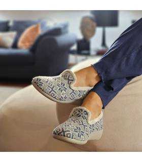 mujer posando en el salon de casa con las zapatillas de dibujos invernales puestas