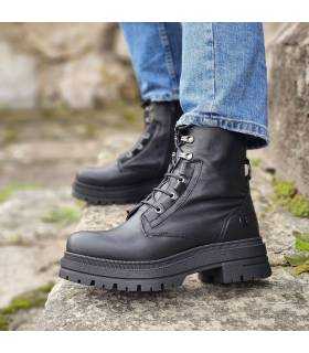 mujer posando con las botas de piel de estilo militar negras puestas