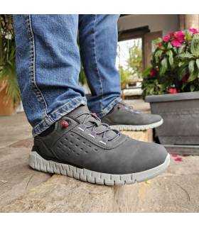 hombre posando con los zapatos deportivos grises de hombre de Dockers puestos