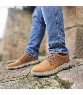 hombre posando con los zapatos marrones slip ins de Skechers puestos