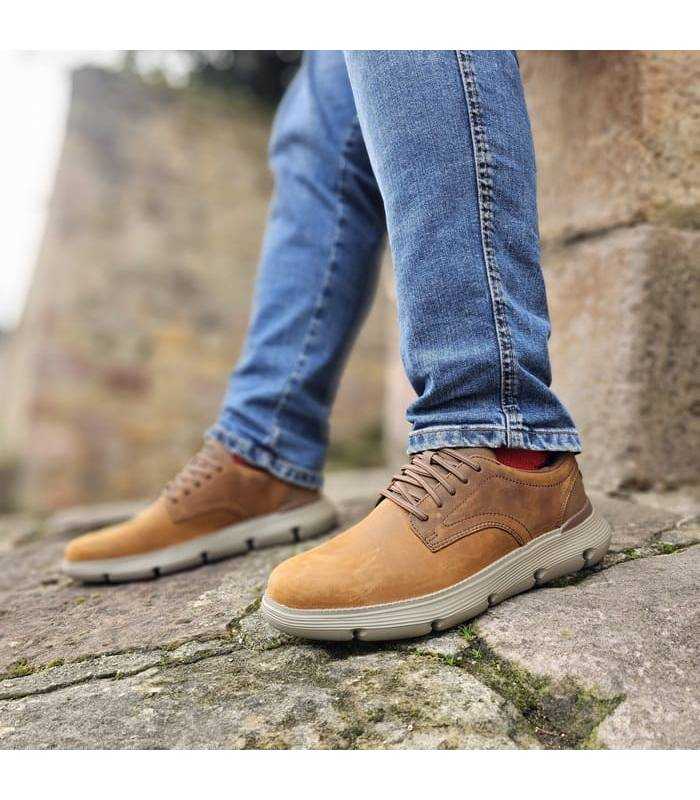 hombre posando con los zapatos marrones slip ins de Skechers puestos