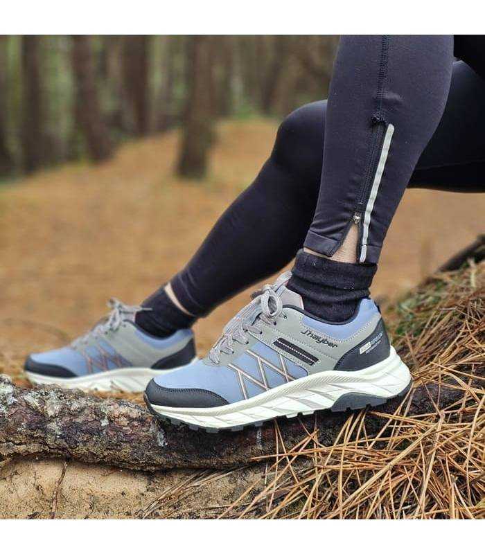 mujer posando en el bosque con las zapatillas azules de jahyber
