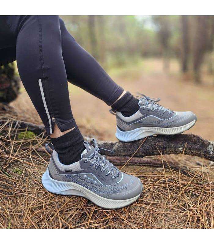 mujer posando sentada en un pinar con las zapatillas de senderismo con gortex de Chiruca azules