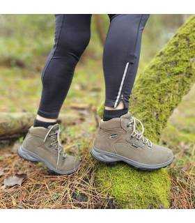 mujer posando sobre troncos con las botas impermeables Massana puestas