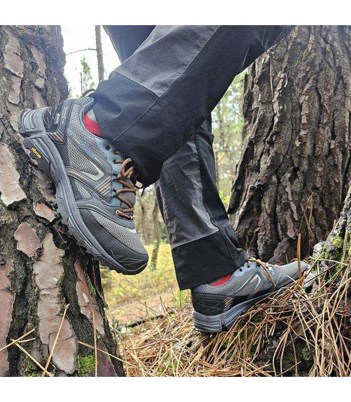 hombre pòsando sobre unos arboles con las zapatillas umtifuncion de Chiruca puestas