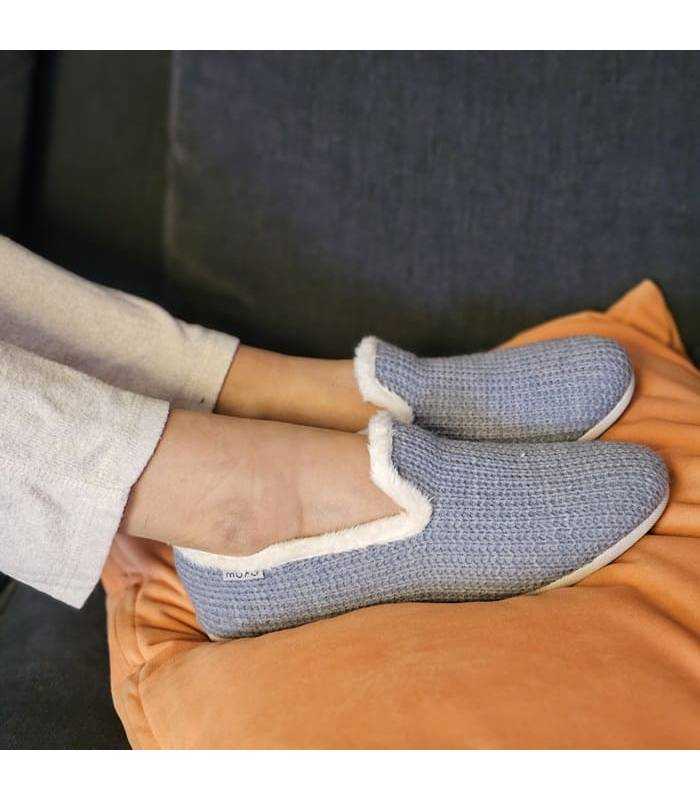 mujer posando con las zapatilñlas de casa para invierno azules puestas