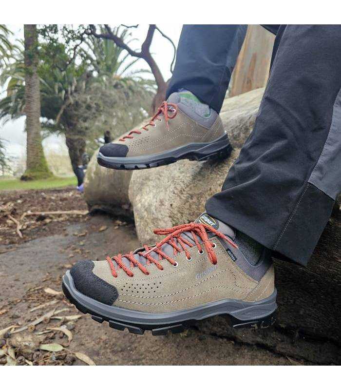 hombr sentado con las zapatillas de senderismo con membrana Gritex puestas