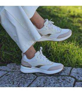 mujer posando con los deportvos con cuña color beige de Skechers