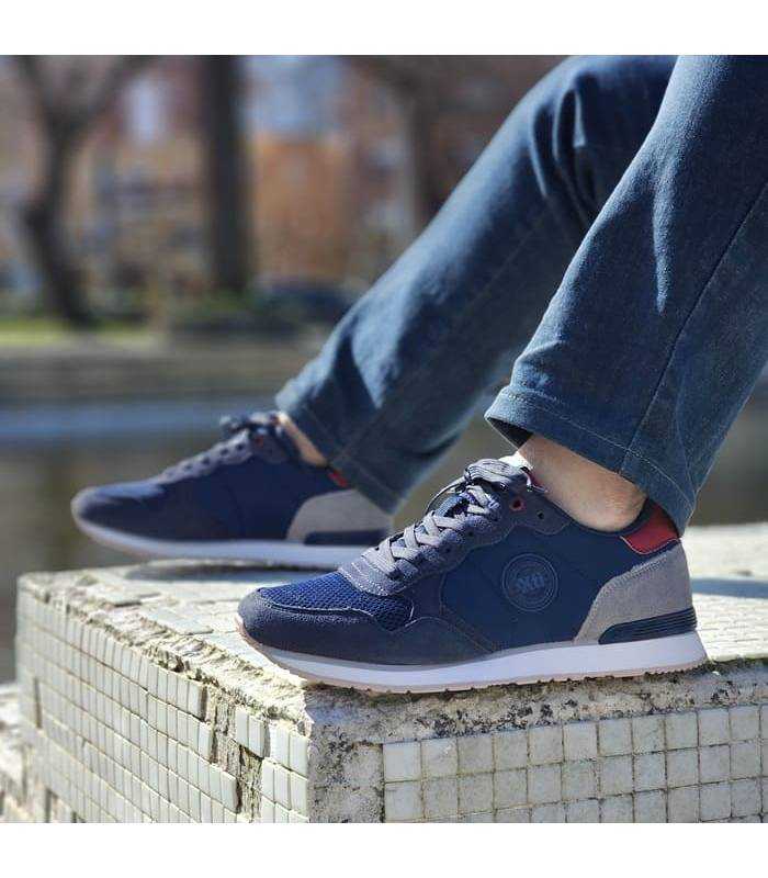 hombre posando con las zapatillas casula azules de Xti puestas