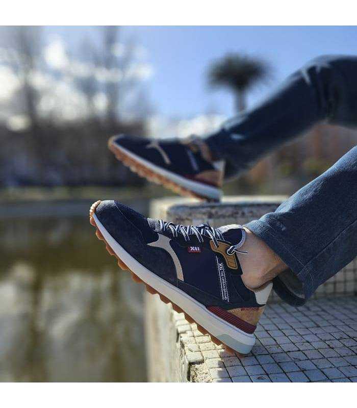 hombre posando con las zapatillas casual azules puestas