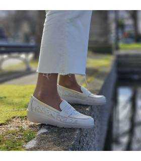 mujer posando junto al estanque con los zapatos comodos de cuña balncos puestos