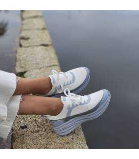 zapatillas deportivas combinadas con pantalones blancos de Skechers puestas