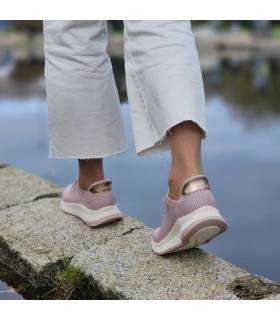 mujer andando con las zapatillas deportivas rosas de Skechers slip-ins